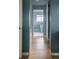Hallway leads to a bathroom with blue walls, white trim, and wood floors at 654 S Shoshone St, Denver, CO 80223