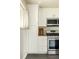 Well-lit kitchen featuring stainless steel stove and oven, white cabinetry, and a view from the window at 654 S Shoshone St, Denver, CO 80223