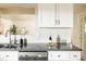 Bright kitchen featuring stainless steel sink with modern faucet, white cabinets, and gray counter tops at 654 S Shoshone St, Denver, CO 80223