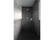 Sleek shower with black tile, a modern shower head, and a built-in shelf at 654 S Shoshone St, Denver, CO 80223