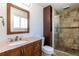 Bathroom with a wooden vanity, granite countertop, tiled shower with glass door, and decorative tiled backsplash at 3256 S Nucla St, Aurora, CO 80013