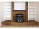Close-up of living room fireplace with brick surround, white built-in shelving, and wood burning stove at 3256 S Nucla St, Aurora, CO 80013