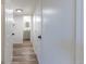 Hallway with wood floors that leads to other areas, including bathroom with vanity and white cabinets at 3256 S Nucla St, Aurora, CO 80013