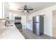 Modern kitchen with white cabinets, stainless steel appliances, gray wood-look flooring, and a ceiling fan at 3256 S Nucla St, Aurora, CO 80013