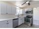 Modern kitchen with stainless steel appliances, white cabinets, quartz countertops, and stylish gray wood-look flooring at 3256 S Nucla St, Aurora, CO 80013
