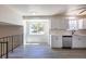 Bright, open kitchen featuring a breakfast bar, stainless appliances, white cabinets, and wood-look flooring at 3256 S Nucla St, Aurora, CO 80013