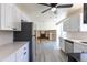 Well-lit open-concept kitchen featuring white cabinets, stainless steel appliances, and modern gray flooring at 3256 S Nucla St, Aurora, CO 80013