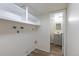 Bright laundry room with overhead storage and wood-look flooring, plus access to a convenient half bath at 3256 S Nucla St, Aurora, CO 80013