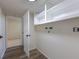 Bright laundry room with overhead storage and wood-look flooring; access to another room at 3256 S Nucla St, Aurora, CO 80013