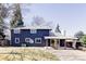 The backyard features a covered patio, blue siding and a well maintained lawn at 3100 S Holly Pl, Denver, CO 80222