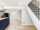 Finished basement with kitchenette, featuring modern cabinets, shelving, and a staircase leading upwards at 3100 S Holly Pl, Denver, CO 80222