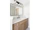 Elegant bathroom features a wood vanity, modern lighting, and a sleek mirror, creating a stylish space at 3100 S Holly Pl, Denver, CO 80222