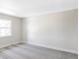Clean, carpeted bedroom showcasing natural light from the window, offering a blank canvas for customization at 3100 S Holly Pl, Denver, CO 80222