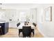 Bright dining room with table set and view into the open kitchen with white cabinets at 3100 S Holly Pl, Denver, CO 80222