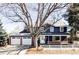 Charming two-story home featuring a two-car garage, brick accents, and a well-maintained front yard at 3100 S Holly Pl, Denver, CO 80222