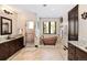 Bathroom featuring a copper tub, tiled floors, vanity with granite counter, and a glass enclosed shower at 8294 Wild Timber Dr, Franktown, CO 80116