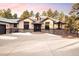 Charming front exterior with stone accents, a three-car garage, and mature trees at 8294 Wild Timber Dr, Franktown, CO 80116