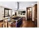 View of open concept kitchen with chef's oven, island seating, hardwood floors and access to the living room and dining area at 8294 Wild Timber Dr, Franktown, CO 80116