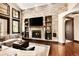 Stunning living room with a stone fireplace wall, built-in shelving, and bright, natural lighting at 8294 Wild Timber Dr, Franktown, CO 80116