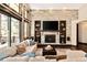 Cozy living room with stone accent wall, fireplace, built-in shelving, and large windows at 8294 Wild Timber Dr, Franktown, CO 80116