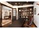 Bright office space featuring custom built-in shelving, coffered ceiling and a leather office chair at 8294 Wild Timber Dr, Franktown, CO 80116