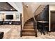 Elegant wooden staircase with wrought iron railing leads to the basement rec room at 8294 Wild Timber Dr, Franktown, CO 80116