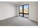 Bright bedroom with neutral carpet, a large black framed window, and white walls at 4487 Utica St, Denver, CO 80211