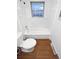 Bright bathroom with a clean white tub/shower combination, and wood grain vinyl flooring at 1045 Mobile St, Aurora, CO 80011
