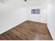 Bedroom featuring wood-look floors, a window, and a door leading outside at 1045 Mobile St, Aurora, CO 80011