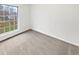 Carpeted bedroom with view of backyard through large window. The walls are white at 1045 Mobile St, Aurora, CO 80011