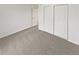 A gray-carpeted bedroom has an entrance and a closet with large, sliding doors at 1045 Mobile St, Aurora, CO 80011