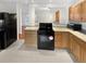 Kitchen with cabinets, stone countertops, tile floors, and black appliances at 1045 Mobile St, Aurora, CO 80011