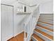Staircase featuring white risers, wood treads, a white banister, and a closet to the left at 1045 Mobile St, Aurora, CO 80011