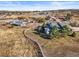 Aerial view of a beautiful property featuring multiple buildings, lush trees, and perimeter fencing at 595 W Oak Hill Ln, Castle Rock, CO 80108