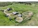 Expansive horse property with white fencing, horse barn, outbuildings, and lush green pastures at 595 W Oak Hill Ln, Castle Rock, CO 80108