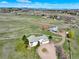 Aerial view of the property showcasing horse facilities, home, fenced yard, and serene landscape at 595 W Oak Hill Ln, Castle Rock, CO 80108