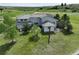 The back of a large stucco house featuring a tile roof and sprawling green yard with mature trees at 595 W Oak Hill Ln, Castle Rock, CO 80108