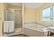 Bright bathroom featuring a large soaking tub and a separate shower with a glass door at 595 W Oak Hill Ln, Castle Rock, CO 80108