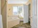 Bright bathroom with a soaking tub, shower, and adjacent toilet room at 595 W Oak Hill Ln, Castle Rock, CO 80108