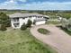 A beautiful home featuring a stucco exterior, tile roof, circular driveway, and attached garage at 595 W Oak Hill Ln, Castle Rock, CO 80108