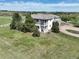 View of the home with two balconies, a circular driveway, bordered by mature trees and a white fence in the background at 595 W Oak Hill Ln, Castle Rock, CO 80108