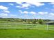 Scenic view of a green pasture with a white fence, providing ample space for horses to graze and enjoy the outdoors at 595 W Oak Hill Ln, Castle Rock, CO 80108