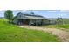 Well-maintained horse barn with open stalls, ample storage, and a covered area for equipment at 595 W Oak Hill Ln, Castle Rock, CO 80108