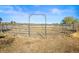 Fenced horse corral with metal panels and gate set against a clear blue sky at 595 W Oak Hill Ln, Castle Rock, CO 80108