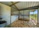 Spacious horse stall featuring wood shavings, metal bars, and an open doorway to the pasture at 595 W Oak Hill Ln, Castle Rock, CO 80108