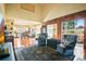 Bright living room featuring hardwood floors, brick accent wall, and seamless open floor plan to kitchen at 595 W Oak Hill Ln, Castle Rock, CO 80108