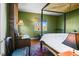 Bedroom with a four poster bed, red brick wall, and a bright window view at 595 W Oak Hill Ln, Castle Rock, CO 80108