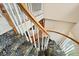 A winding staircase with dark patterned carpet and wood and white railing at 595 W Oak Hill Ln, Castle Rock, CO 80108