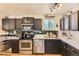 Modern kitchen features stainless steel appliances, ample counter space, and stylish dark cabinets at 1756 S Memphis St, Aurora, CO 80017