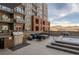 Luxury rooftop patio with built-in grill, hot tub, modern seating, and stunning city views at 20 Wilcox St # 203, Castle Rock, CO 80104